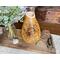 This shows a dinning room centerpiece featuring a handmade gourd vase. The vase has hand-drawn sunflower artwork on the front. 